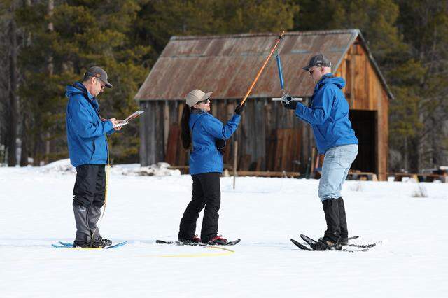 A team with the California Department of Water Resources measures snow along Highway 50 near Lake Tahoe on Jan. 30, 2026. They are, from left, engineer Jacob Kollen, hydrometeorologist Angelique Fabbiani-Leon and Andy Reising, snow survey and water supply forecasting manager.